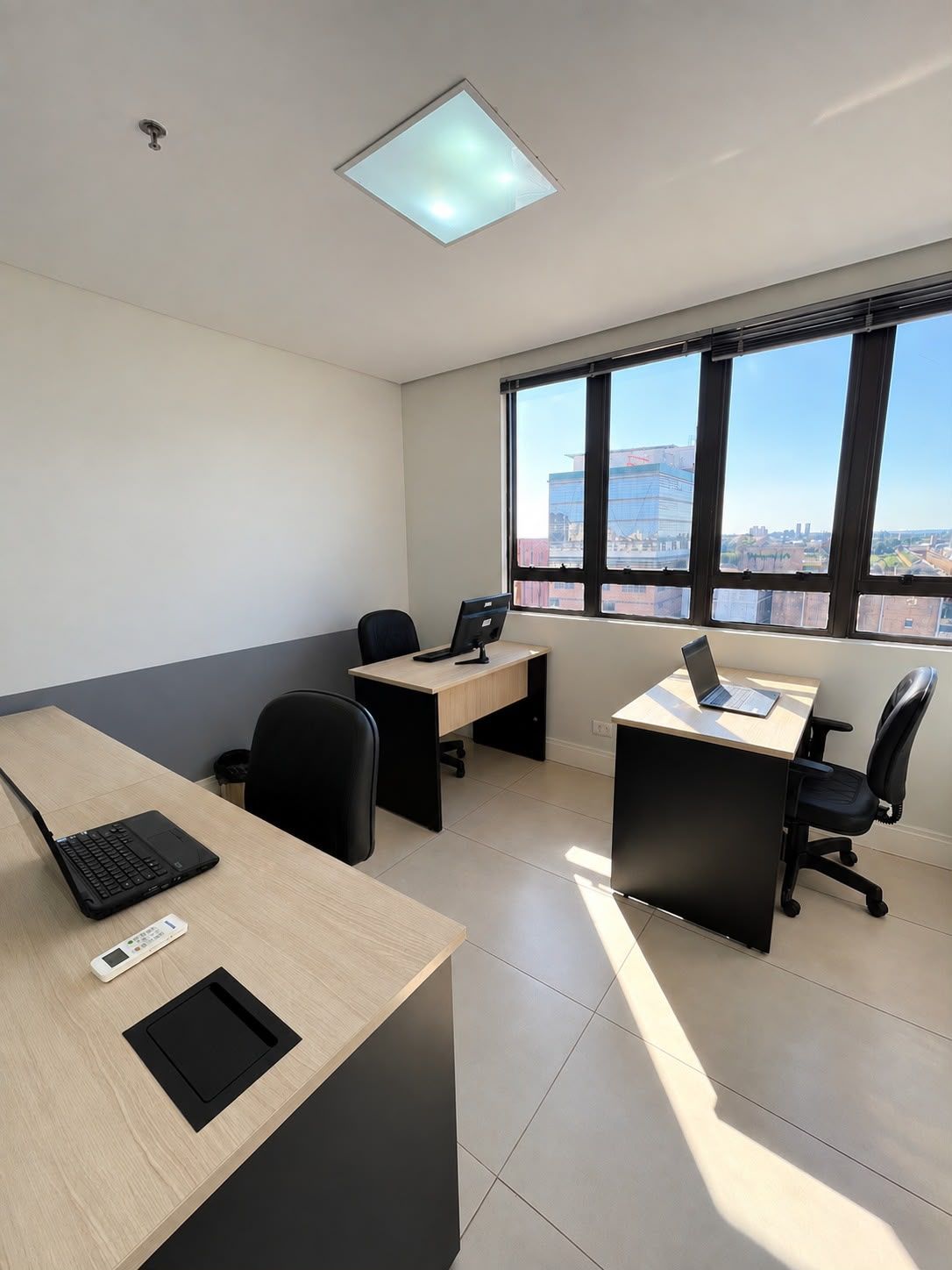 Sala executiva com janelas amplas e vista da cidade